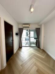 Bright main living area with wood flooring and access to a balcony