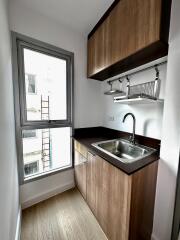 Compact modern kitchen with wooden cabinets and a large window