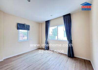 Empty bedroom with wooden floor and large windows