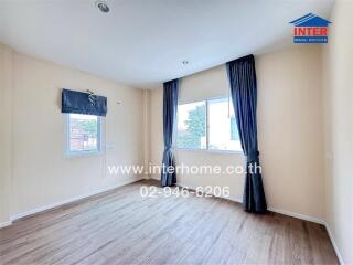 Empty bedroom with wooden floor and large windows