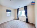 Empty bedroom with wooden floor and large windows