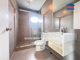 Modern bathroom with shower enclosure, sink, and toilet