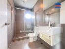 Modern bathroom with shower enclosure, sink, and toilet