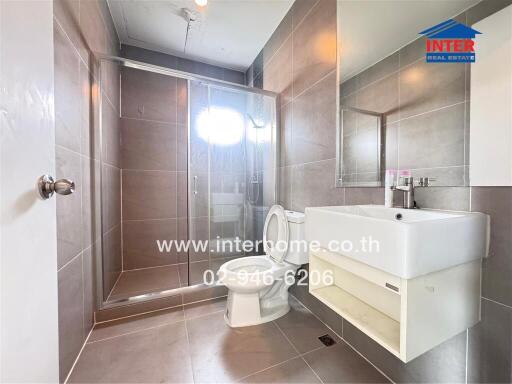 Modern bathroom with shower enclosure, sink, and toilet