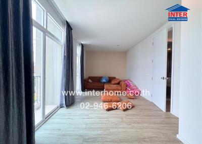 Living room with a large window, couch and wooden flooring