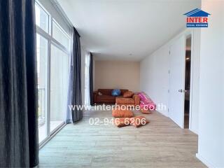 Living room with a large window, couch and wooden flooring