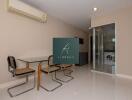 Modern dining area with glass table and washer/dryer in the background