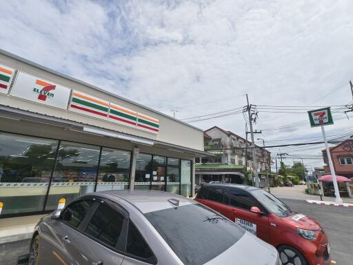 Exterior view of a 7-Eleven store and parked cars