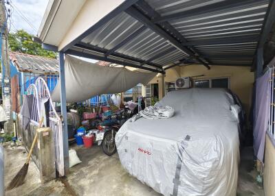 covered garage area with parked vehicle and miscellaneous items