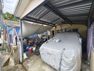 covered garage area with parked vehicle and miscellaneous items