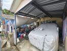 covered garage area with parked vehicle and miscellaneous items