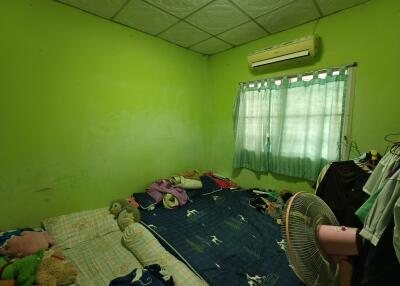 Bedroom with green walls, bed, air conditioner, and fan