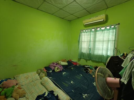 Bedroom with green walls, bed, air conditioner, and fan