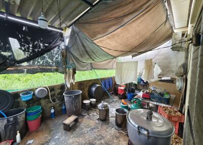 Outdoor utility area with cooking pots and storage