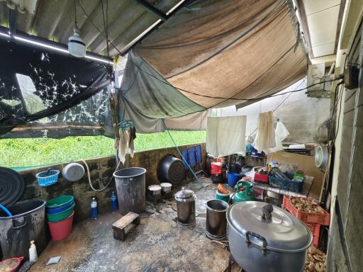 Outdoor utility area with cooking pots and storage