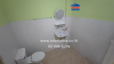 Bathroom with a toilet, sink, and mirror