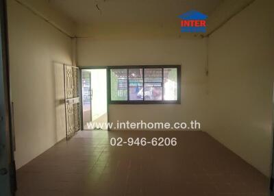 Empty living room with tiled floor and large window