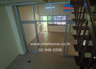 Spacious living area with stair access and glass doors