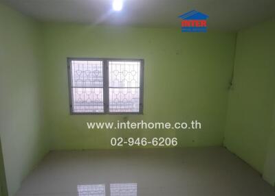 Empty bedroom with tiled floor and barred window