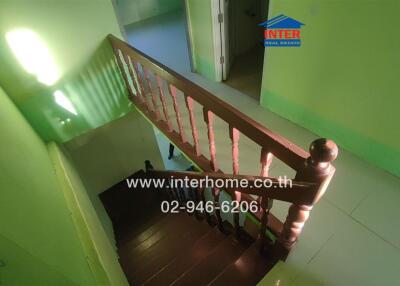 Wooden staircase with railing in green painted interior