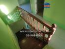 Wooden staircase with railing in green painted interior