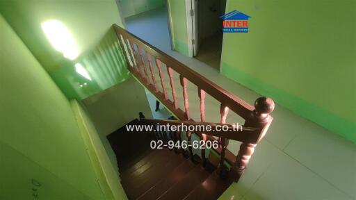 Wooden staircase with railing in green painted interior