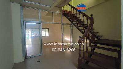 Main living space with staircase and glass partition