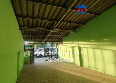 Covered parking space with a green wall and metal roof