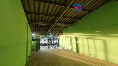 Covered parking space with a green wall and metal roof