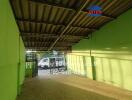 Covered parking space with a green wall and metal roof