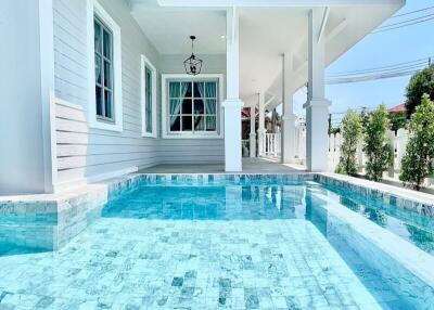 Outdoor pool area with a view of the house exterior