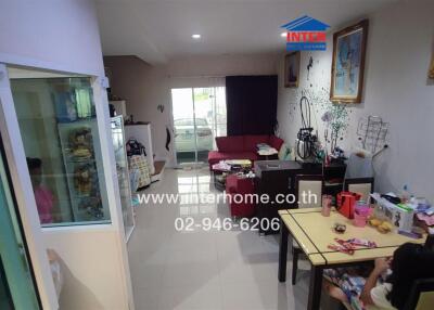 Main living area with dining table, sofa, and view of the entrance