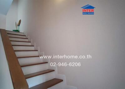 Interior staircase with wooden steps and white walls in a residential property