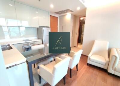 Modern kitchen and dining area with sleek, white cabinetry and appliances.