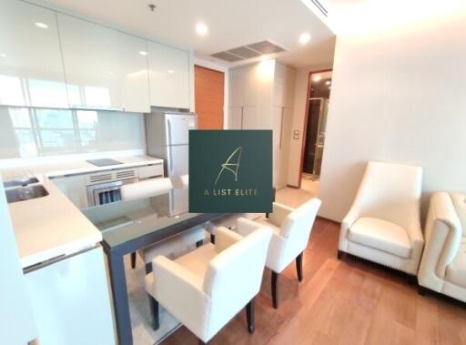 Modern kitchen and dining area with sleek, white cabinetry and appliances.