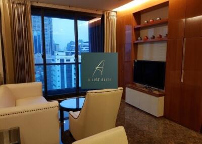 Modern living room with city view, featuring comfortable seating and a wall-mounted TV