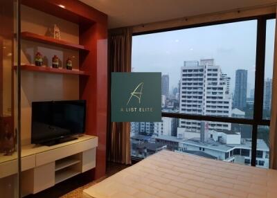 Bedroom with a view of the city skyline, featuring a TV and a comfortable bed