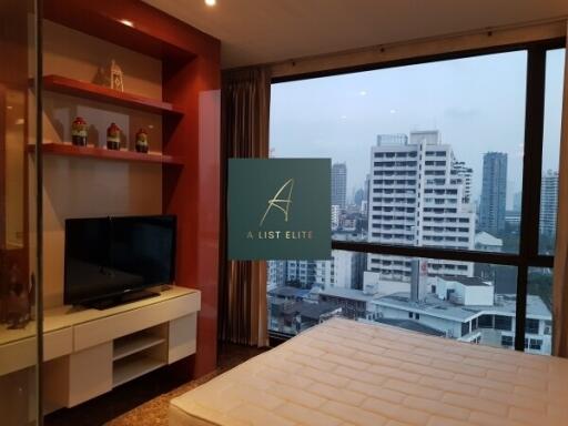 Bedroom with a view of the city skyline, featuring a TV and a comfortable bed