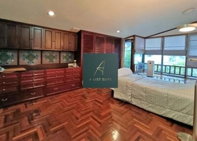 Spacious bedroom with wooden cabinets and parquet flooring