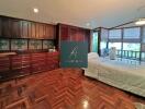 Spacious bedroom with wooden cabinets and parquet flooring