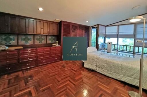 Spacious bedroom with wooden cabinets and parquet flooring