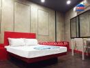 Modern bedroom with a red themed bed and wall-mounted amenities