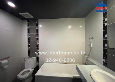 Modern bathroom with bathtub, shower, and toilet