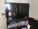 Living room with TV, bookcase, and air conditioner