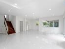 spacious main living area with staircase, large windows, and glossy tiles