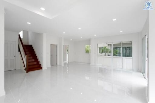 spacious main living area with staircase, large windows, and glossy tiles