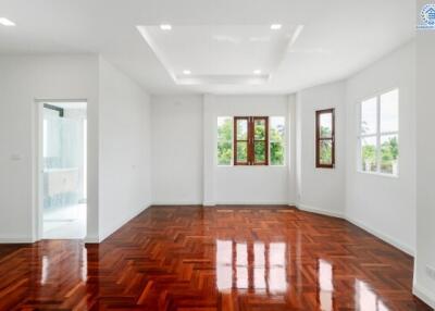 Spacious and well-lit living room with wooden floors and large windows