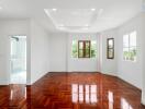 Spacious and well-lit living room with wooden floors and large windows