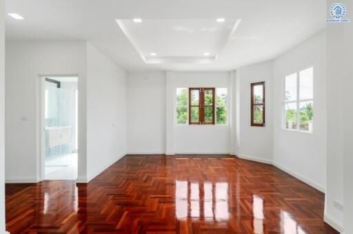 Spacious and well-lit living room with wooden floors and large windows