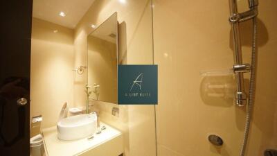 Clean and modern bathroom with a washbasin, mirror, and shower.